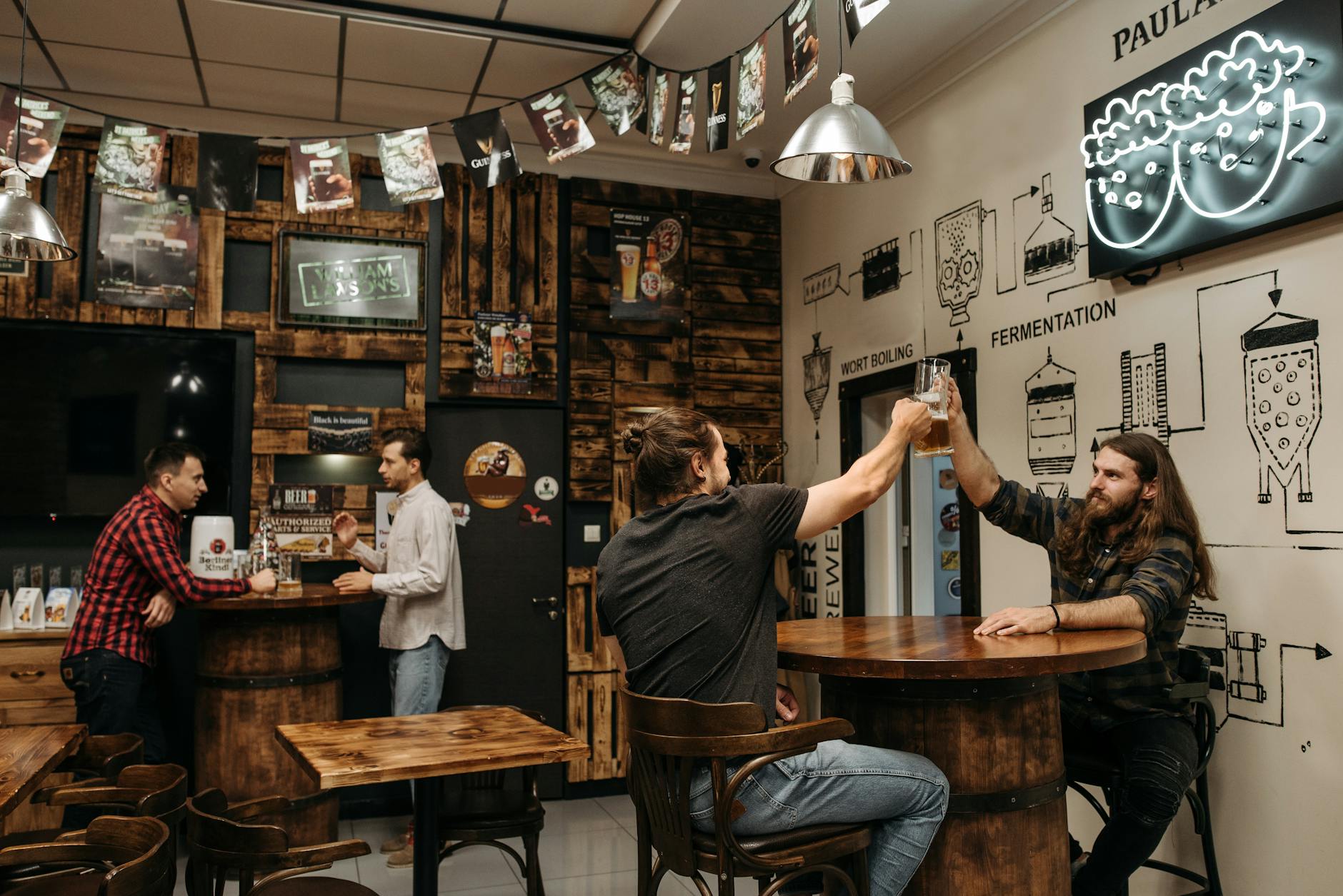 A group of friends raising glasses of beer together at a Miami bar