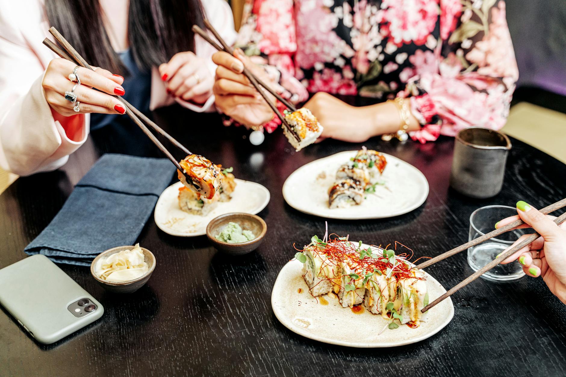 Friends sharing a meal at a communal food hall table in Miami