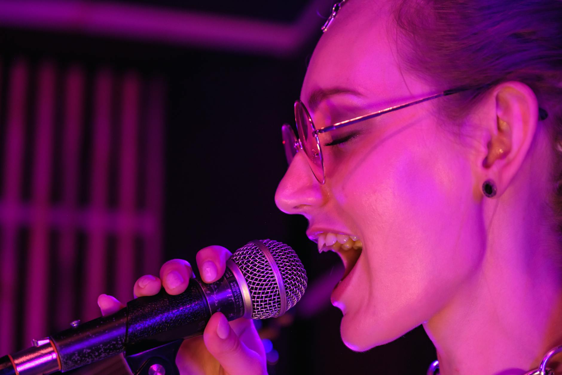 Latin pop vocalist singing into a microphone on stage in Miami