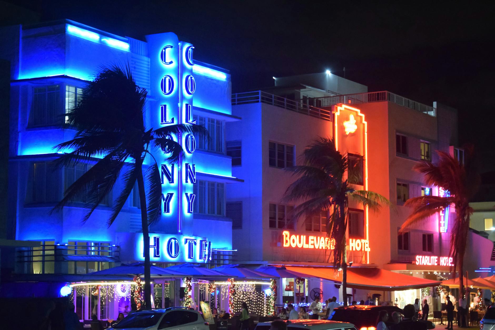 Neon-lit Art Deco hotels illuminating Ocean Drive at night in Miami Beach