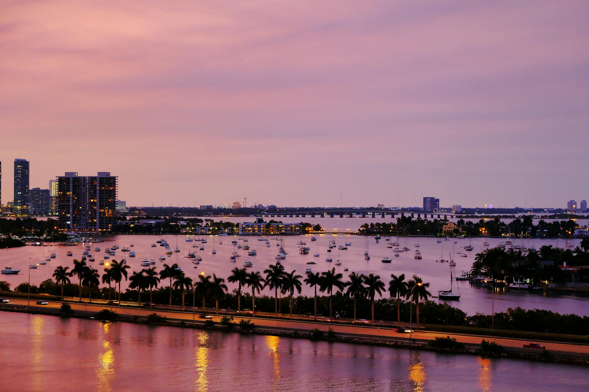 Yacht cruising past the Miami downtown skyline at golden hour