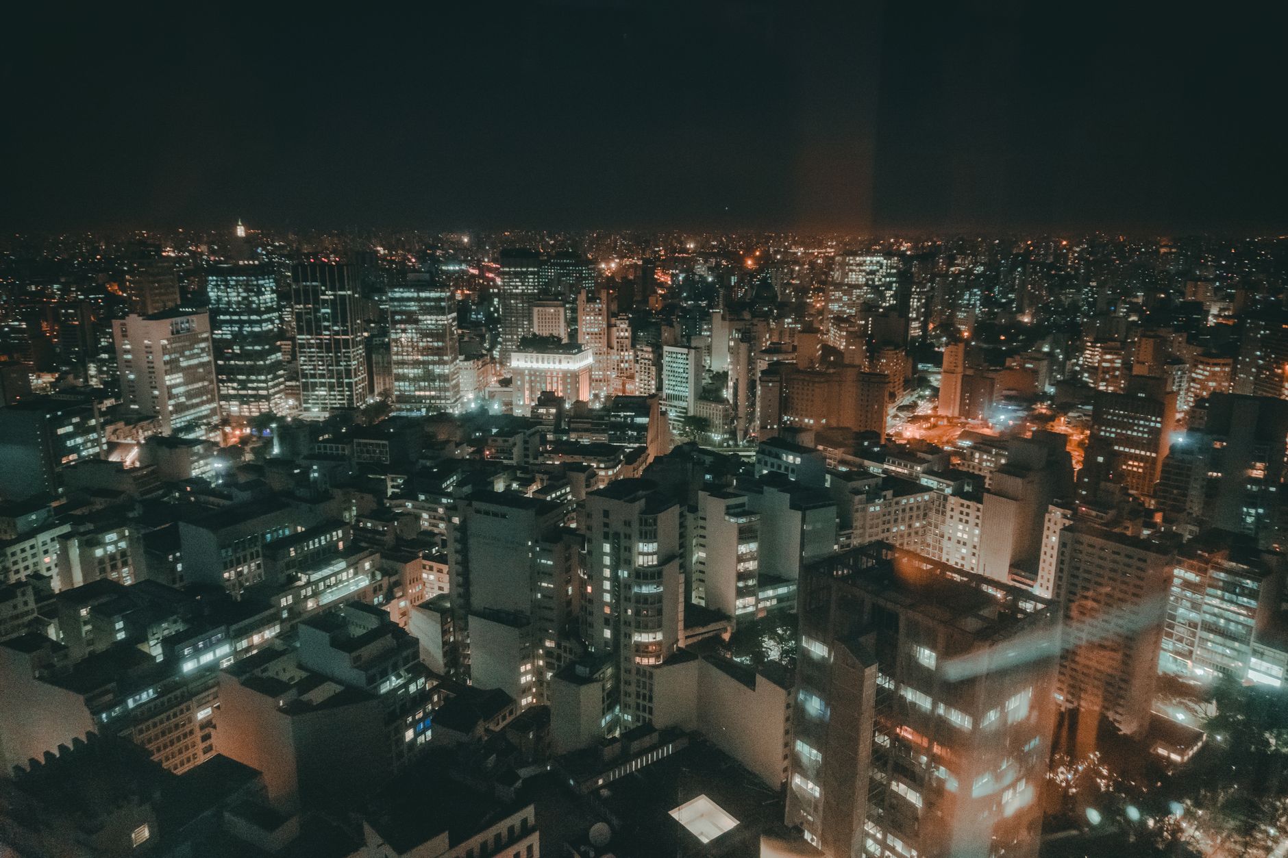 Rooftop bar overlooking a glittering city skyline at night