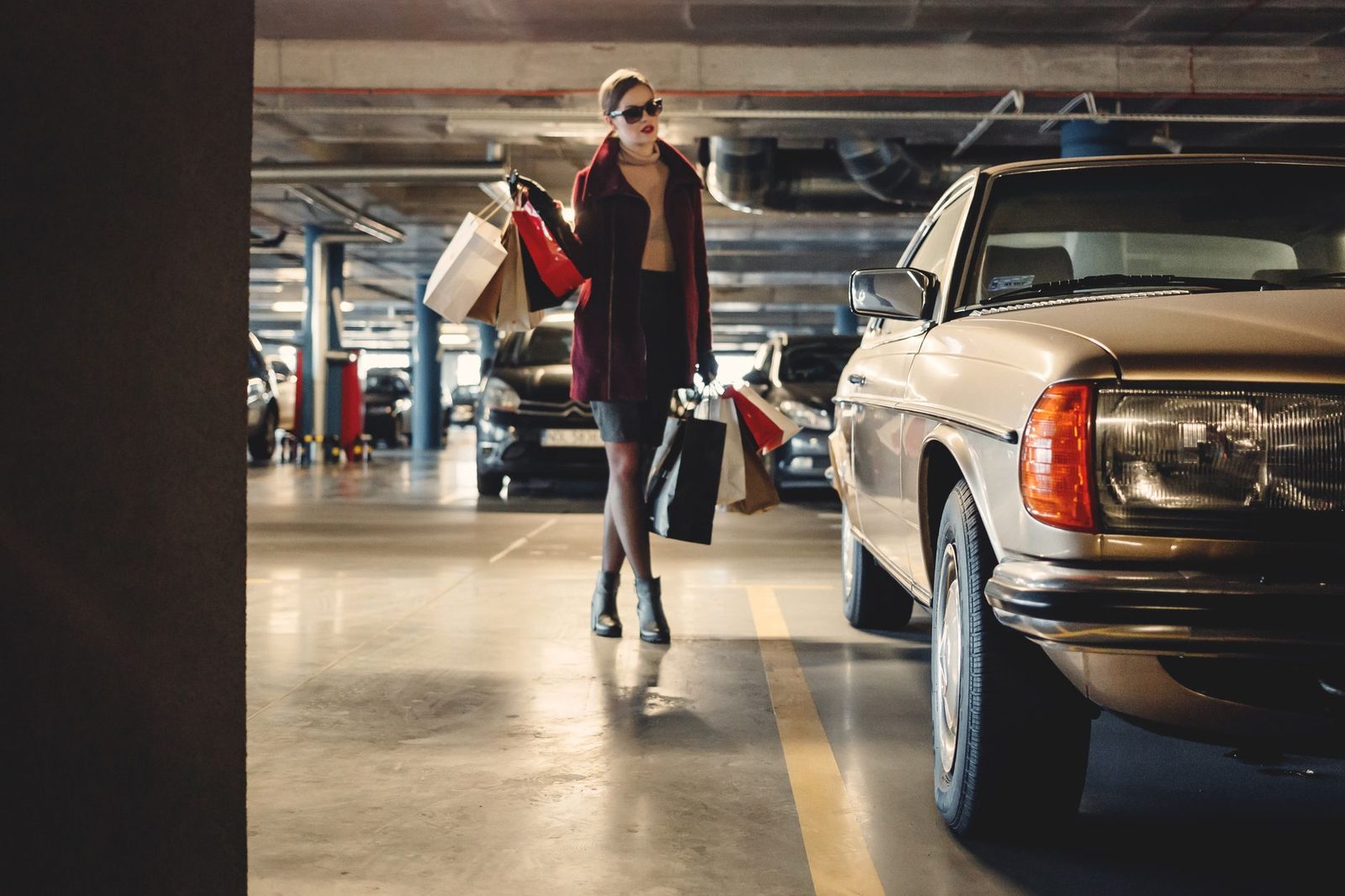 shopper walking through a parking garage with bags