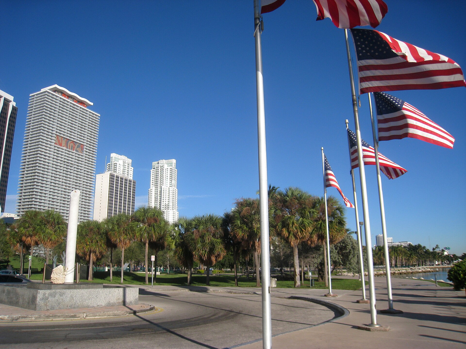 Palm trees, flagpoles and downtown Miami towers along the Bayfront Park promenade on a clear day