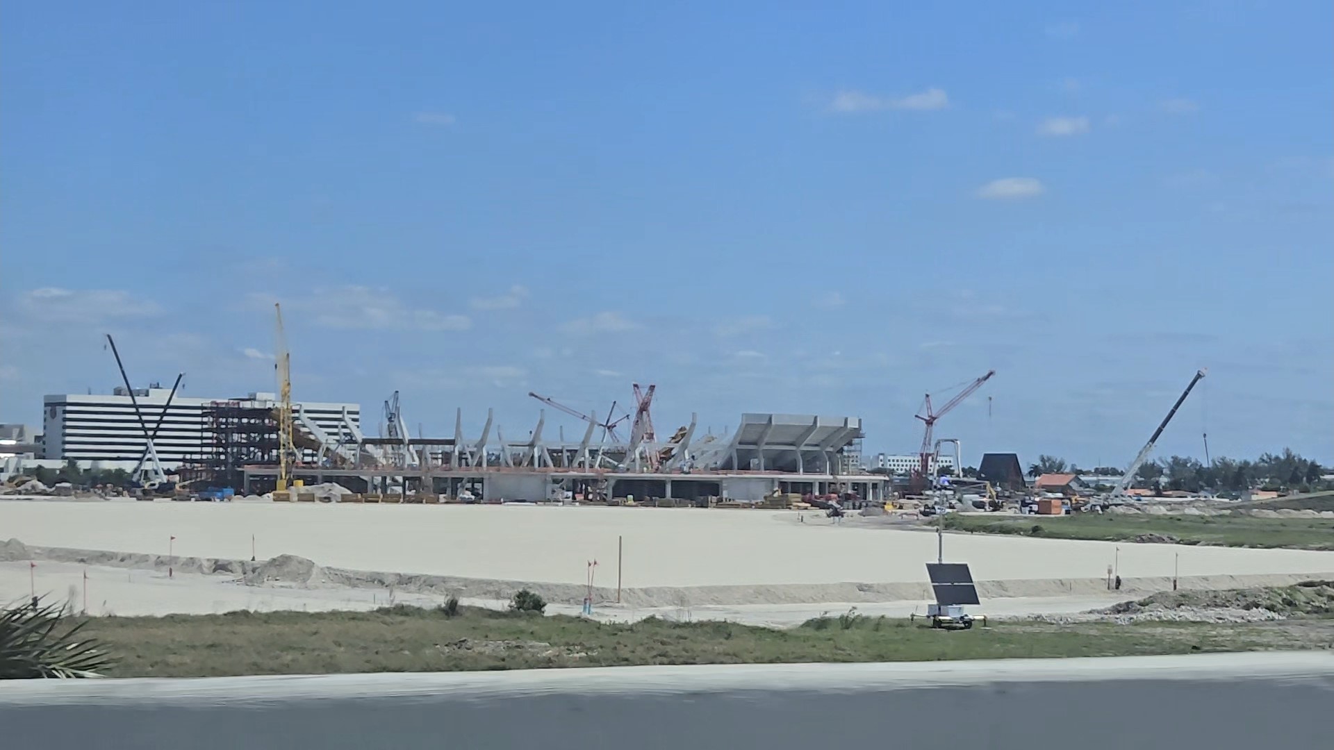 Cranes and the concrete frame of the Nu Stadium stands rising from cleared land beside Miami International Airport in April 2025