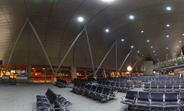 The vaulted concourse of a Miami International Airport terminal with rows of empty seating