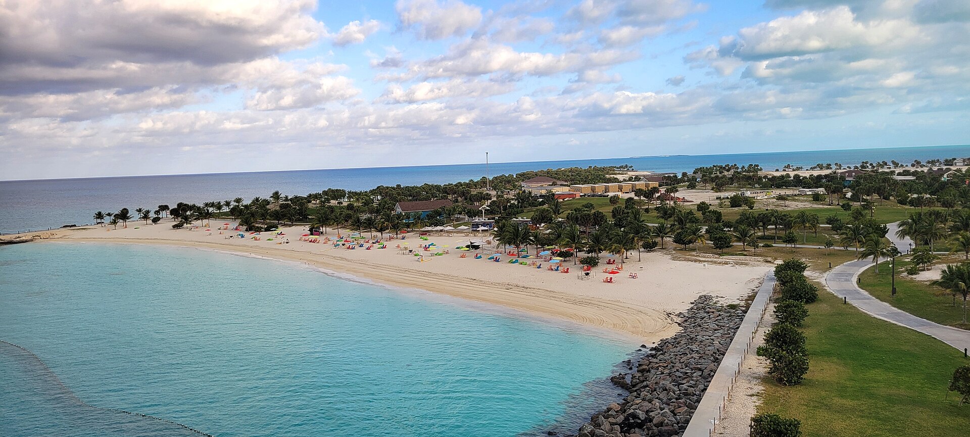 A curved white-sand beach with colorful loungers and turquoise water at Lighthouse Bay, Ocean Cay MSC Marine Reserve