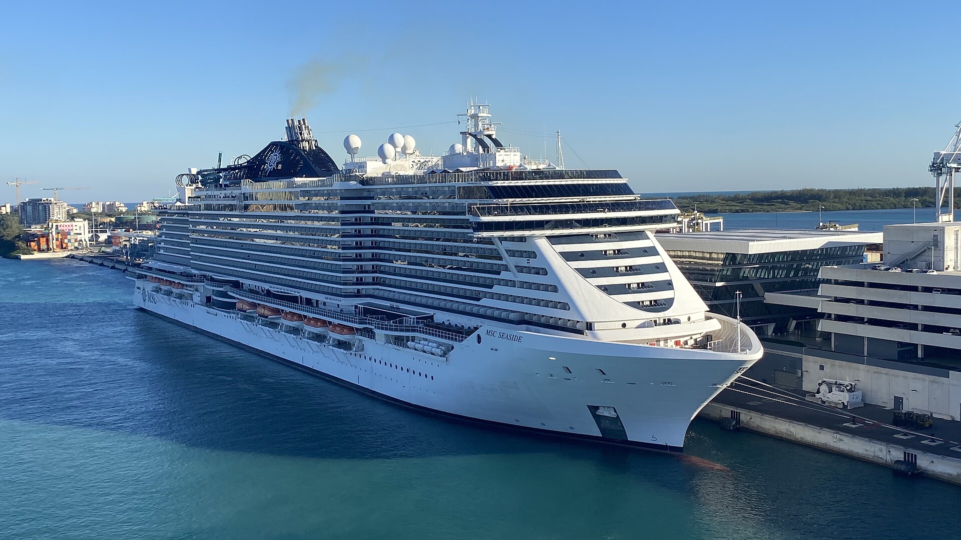 MSC Seaside docked alongside a PortMiami terminal building with its multi-storey parking garage beside it