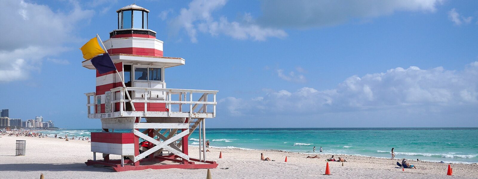 Red and white lifeguard tower at South Pointe Beach with a yellow warning flag flying