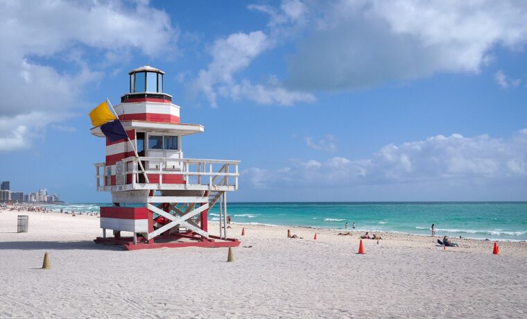 Red and white lifeguard tower at South Pointe Beach with a yellow warning flag flying
