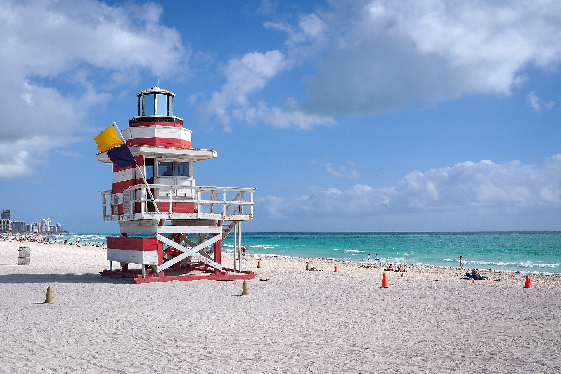 Red and white lifeguard tower at South Pointe Beach with a yellow warning flag flying